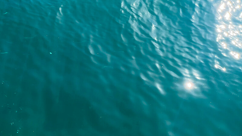 日差しが反射する青い海面のクローズアップ