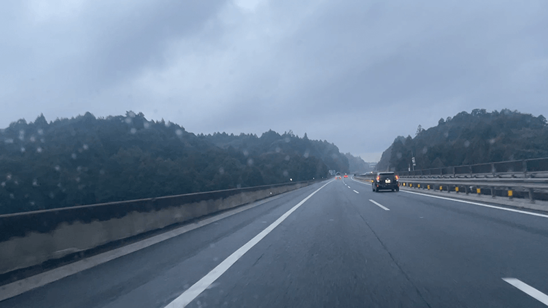 雨雲の下を竹芝へ向かって走る高速道路の車窓