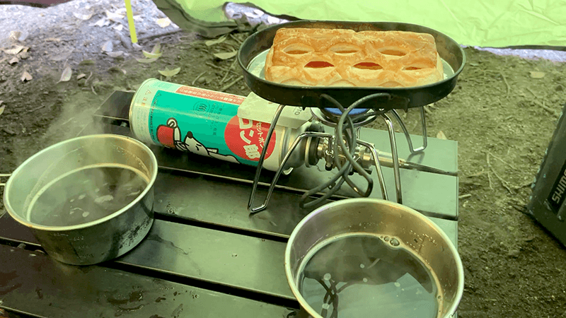 テント前室でパンを焼きながら始まる新島2日目の朝食