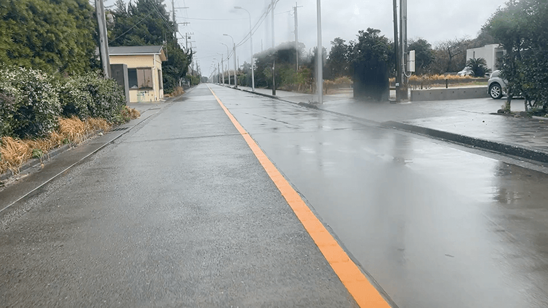 雨で濡れた新島の道路を車で走る島内の風景