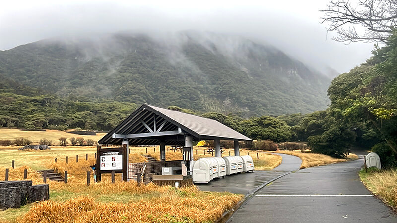 霧のかかる山を背にした羽伏浦キャンプ場