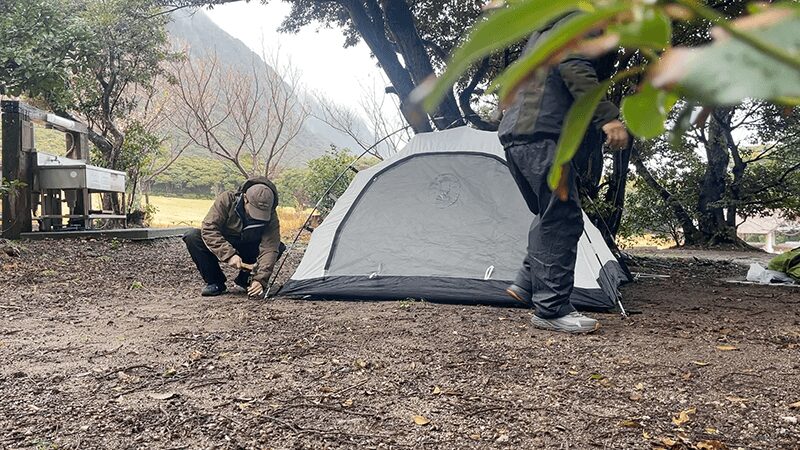 雨のキャンプ場でテントを立てる