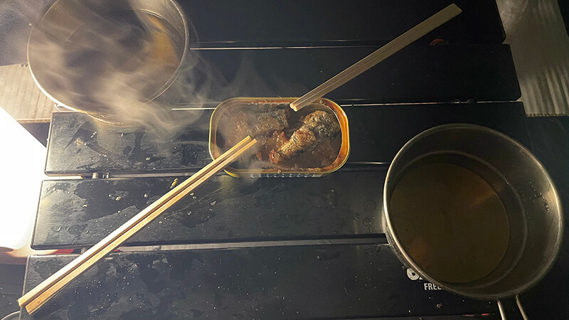 キャンプ場の夜に温める缶詰と晩酌の準備