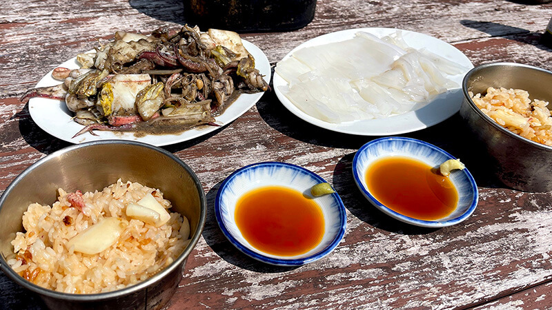 イカ刺しと炊き込みご飯と味噌炒めが並ぶ新島のブランチ