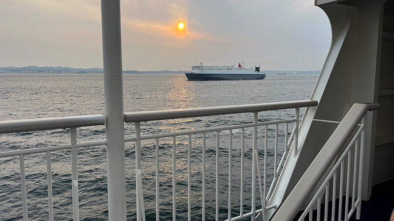 夕方の船上から眺める海と遠くを進む船
