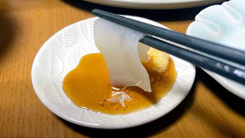 イカ刺しをポン酢につけて食べ比べる様子