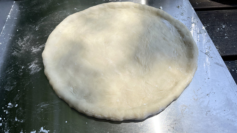 丸く伸ばしてキスピザの具をのせる準備ができた生地
