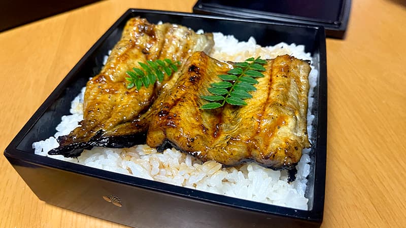 頭寄りと尾の蒲焼に庭の山椒を添えた二段目の鰻重