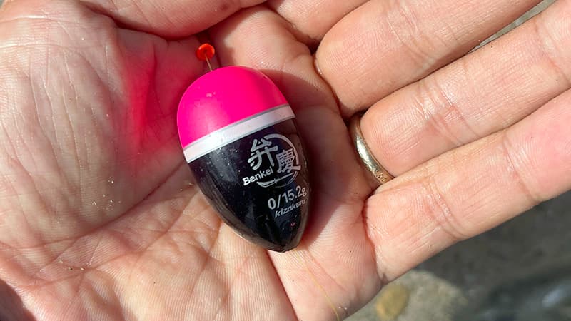 手のひらにのせたキザクラの円錐ウキ、弁慶の0号