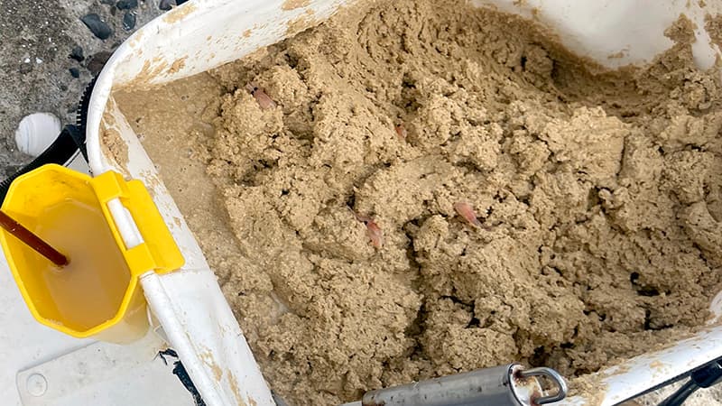 バッカンに入った米ヌカの撒き餌と、黄色い水汲みバケツ