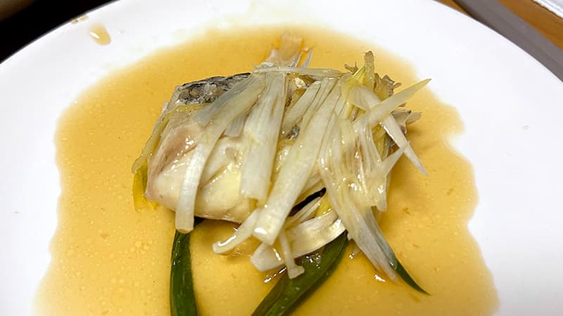 取り分けたスズキの清蒸魚。ネギとたれが染みた身