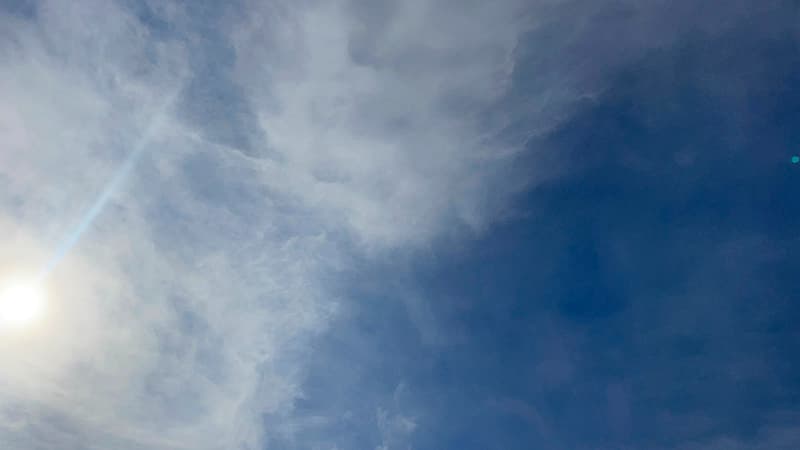 薄い雲が広がる夏の青空と眩しい太陽